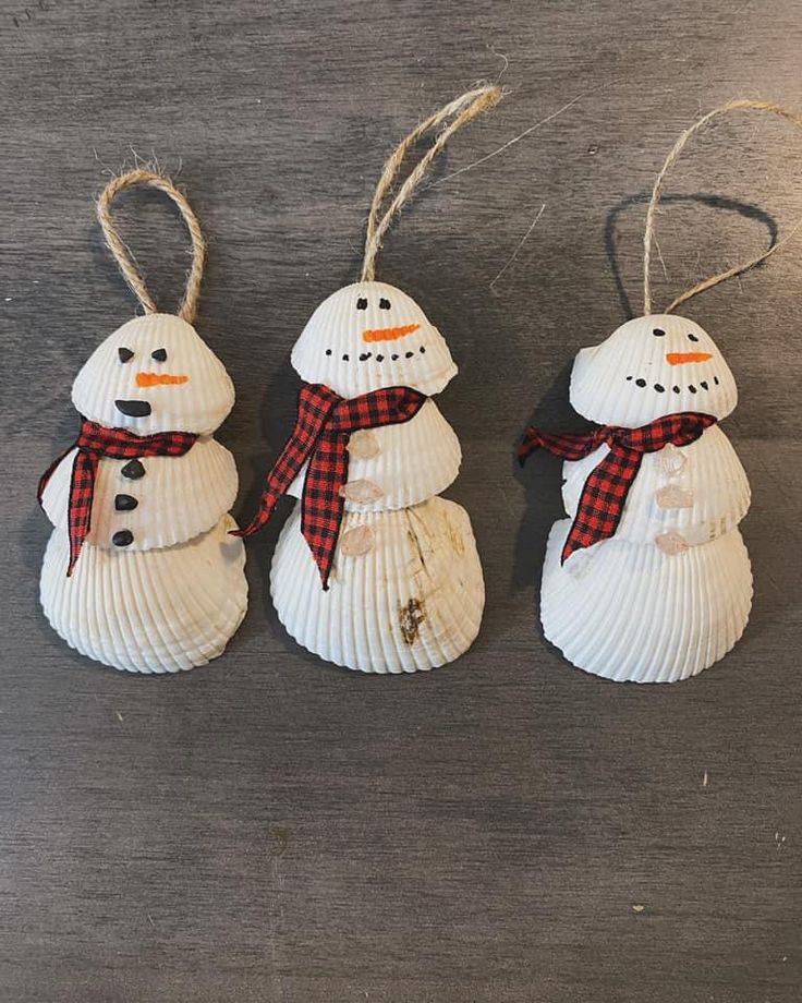 three snowmen made out of seashells on a table