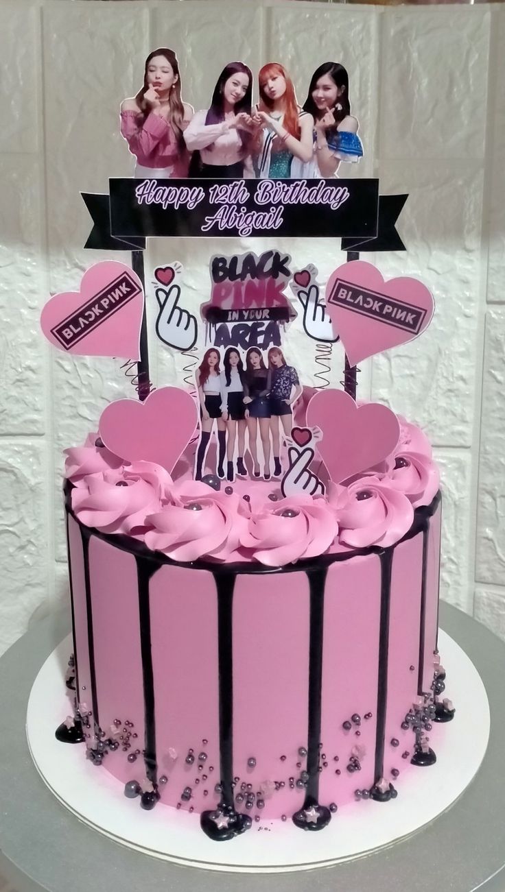 a birthday cake decorated with pink icing and black ribbon on the top, surrounded by hearts