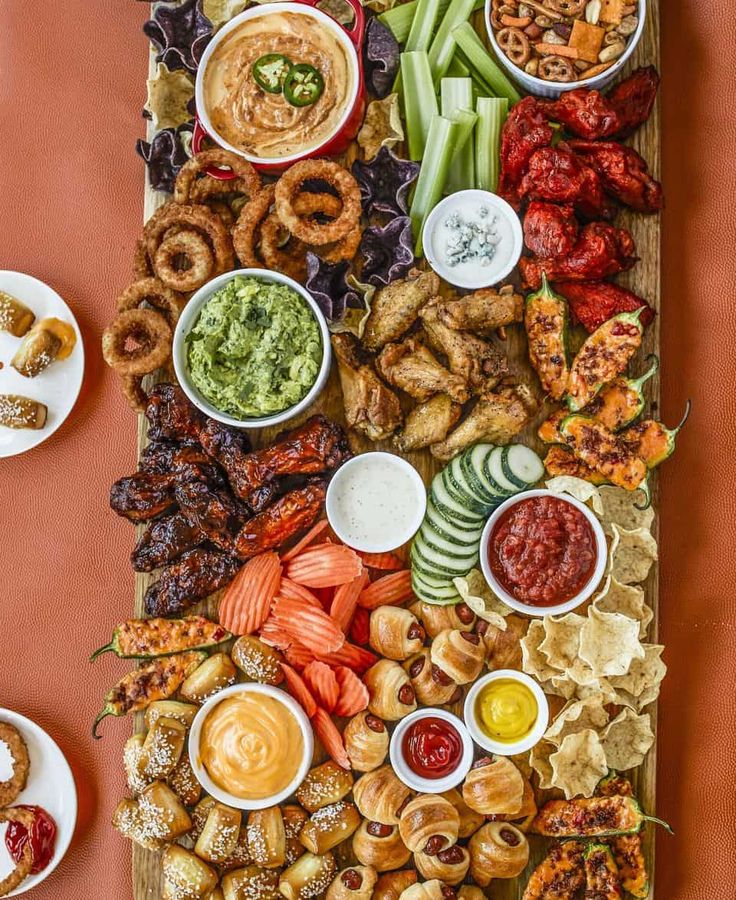 an image of a large platter of food with dips and pretzels