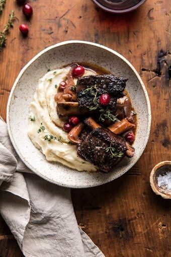 a plate of food with mashed potatoes, meat and cranberries on it