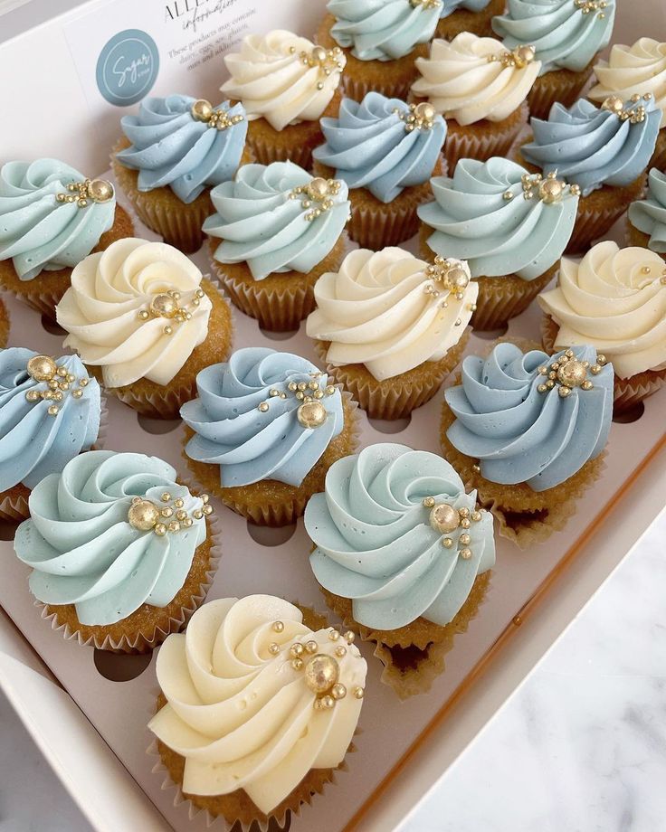 cupcakes with blue and white frosting in a box