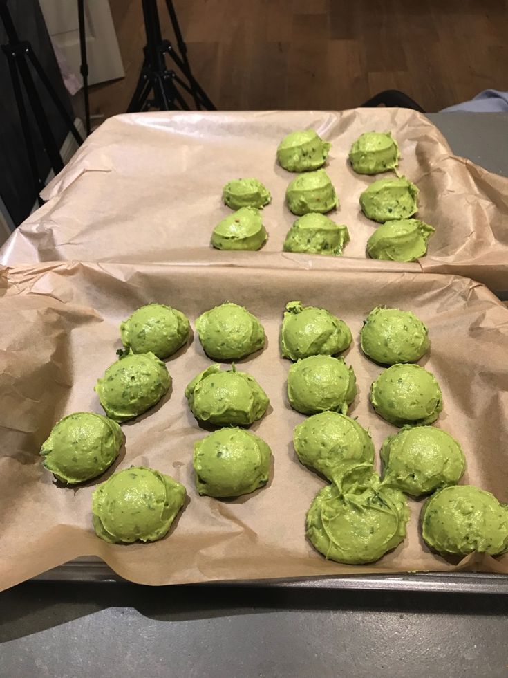 some green cookies are on a baking sheet and ready to be baked in the oven