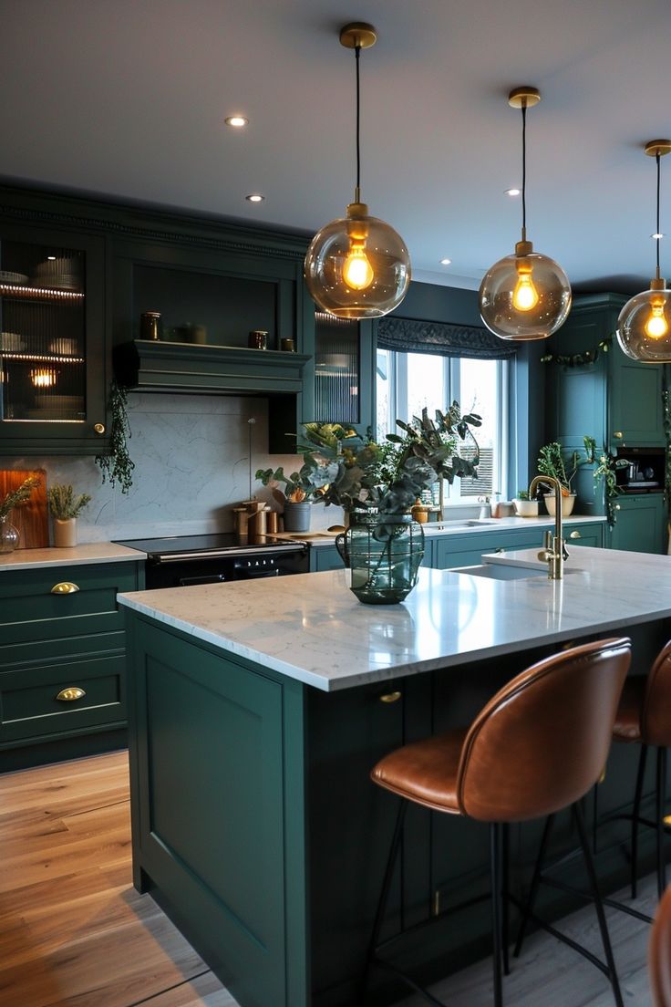 a kitchen with green cabinets and lights hanging from it's ceiling above the island