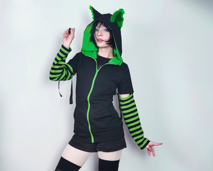 "𝘾𝘼𝙏 𝙀𝘼𝙍𝙎 𝙃𝙊𝙊𝘿𝙄𝙀 - 𝙂𝙍𝙀𝙀𝙉 - 𝙈𝘼𝙇𝙀 / 𝙁𝙀𝙈𝘼𝙇𝙀 𝘾𝙐𝙏 Black cat hoodie with ears. This cat ear hoodie has green fur inside the standing cat ears. 𝗪𝗛𝗔𝗧 𝗪𝗜𝗟𝗟 𝗜 𝗥𝗘𝗖𝗘𝗜𝗩𝗘？ ♥ Zip up hoodie ♥ Hood with cat ears (fur inside) ♥ Detachable sleeves (easy to apply!) ♥ Sleeves with thumbholes ♥ Big pockets to hold your stuff :D 𝗙𝗔𝗕𝗥𝗜𝗖: Cotton sweatshirt, faux fur for the ears 𝗦𝗜𝗭𝗘: Male or female cut. Size chart you will find it on the last photo! For custom si Fitted Green Winter Hoodie, Green Hooded Top With Double-lined Hood, Green Hooded Top With Drawstring, Green Double-lined Hooded Top For Winter, Green Winter Top With Double-lined Hood, Green Winter Cosplay Outerwear, Green Winter Outerwear For Cosplay, Spring Hoodie For Alternative Fashion, Green Tops With Adjustable Hood For Streetwear