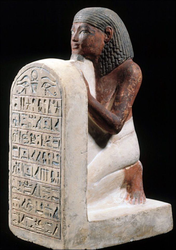 an ancient egyptian statue with writing on it's body and hands in the shape of a kneeling woman