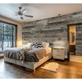 a bedroom with wood paneling and a bed in the middle, next to a large window