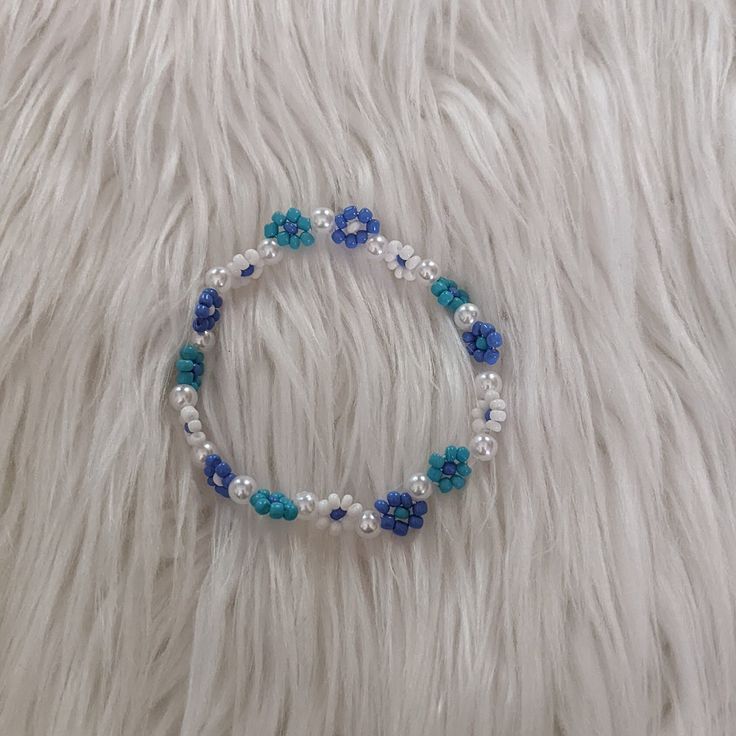 Blue Seed Bead Flower Bracelet Introducing our charming Blue Flower Bracelet, a delightful accessory that effortlessly adds a pop of color to any ensemble. Crafted with stretchy materials, it ensures a comfortable fit tailored to your liking. Don't forget to include your wrist size in the note box below for a personalized experience! Feel free to contact me with any questions or concerns. Thank You! Blue Flower Beaded Bracelets For Beach, Blue Flower Bracelets For Beach, Blue Flexible Casual Bracelet, Casual Blue Flexible Bracelets, Casual Flexible Blue Bracelets, Turquoise Bracelet Spring Gift, Turquoise Flower Bracelets With Colorful Beads, Turquoise Beaded Flower Bracelets, Turquoise Beaded Flower Bracelet