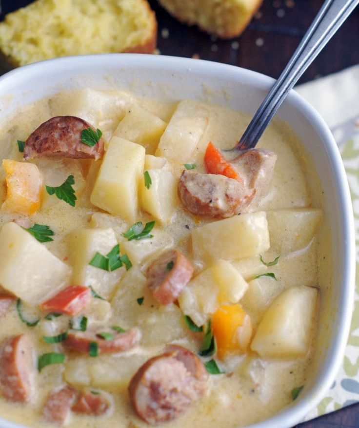 a white bowl filled with potatoes and sausage