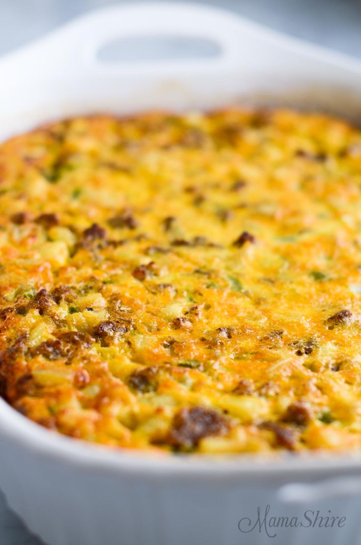 a casserole dish with meat and cheese in it sitting on a white plate