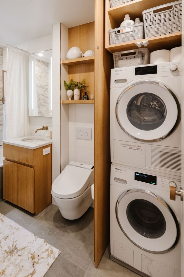 a washer and dryer in a bathroom with wooden shelves above the toilet bowl