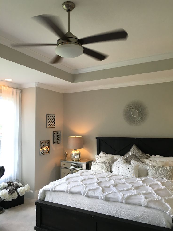 a bedroom with a large bed and ceiling fan in it's centerpieces