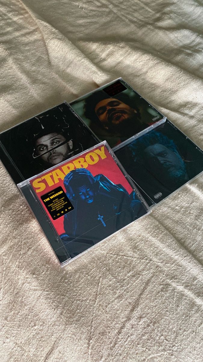 two cds sitting on top of a bed next to each other with the covers pulled down