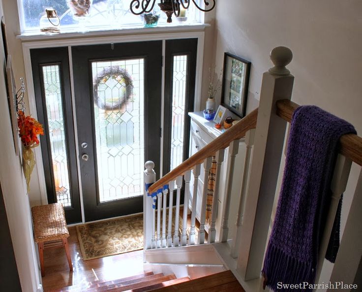 an aerial view of the stairs and entryway to a home with clock on the wall