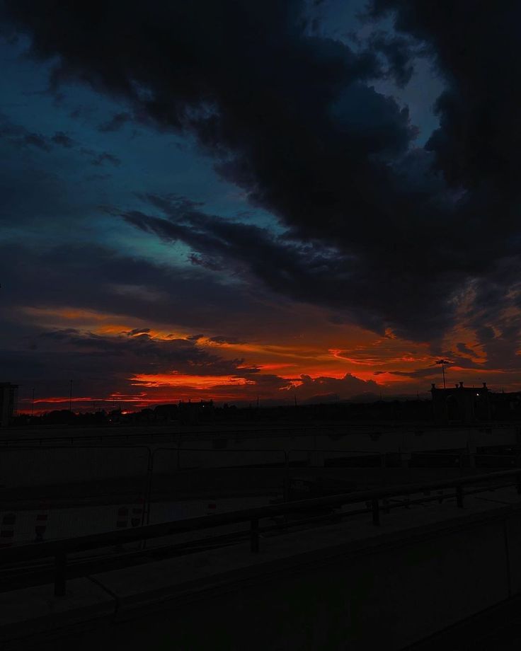 the sun is setting behind some clouds in the sky