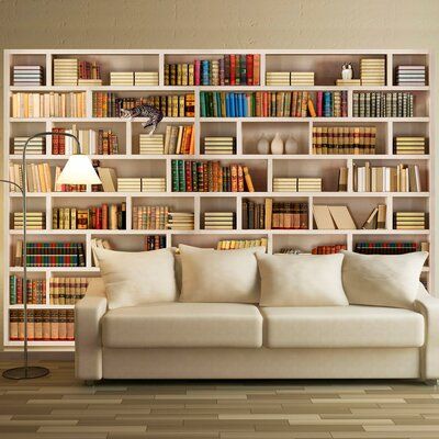 a white couch sitting in front of a bookshelf filled with lots of books