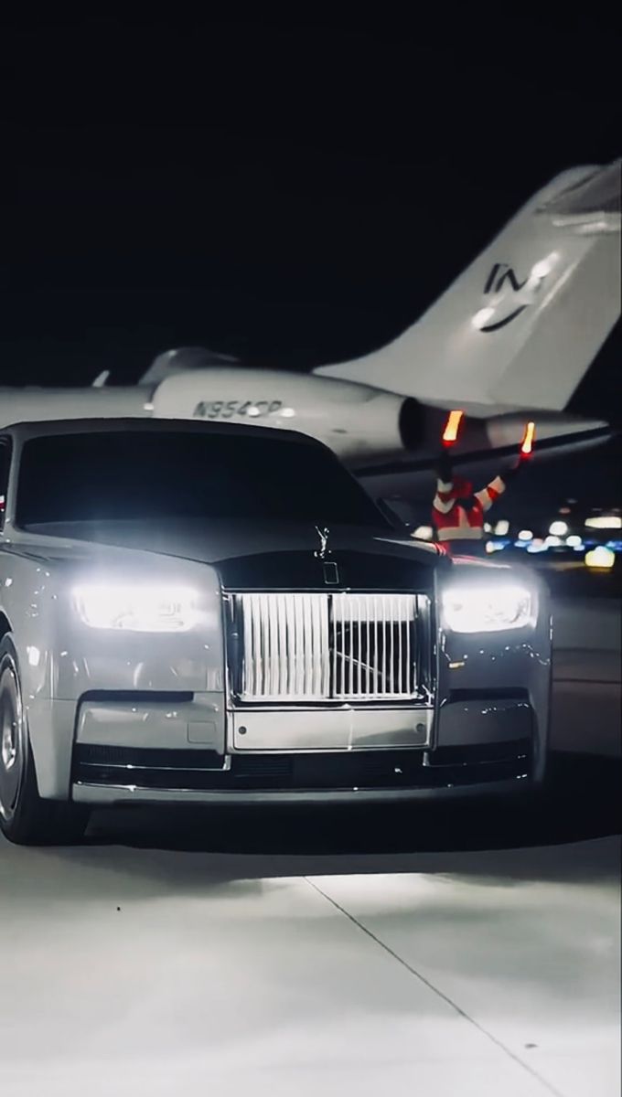 a rolls royce parked in front of an airplane