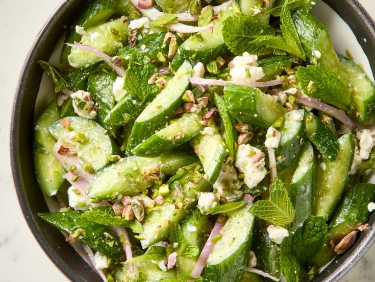 a bowl filled with cucumbers and other vegetables