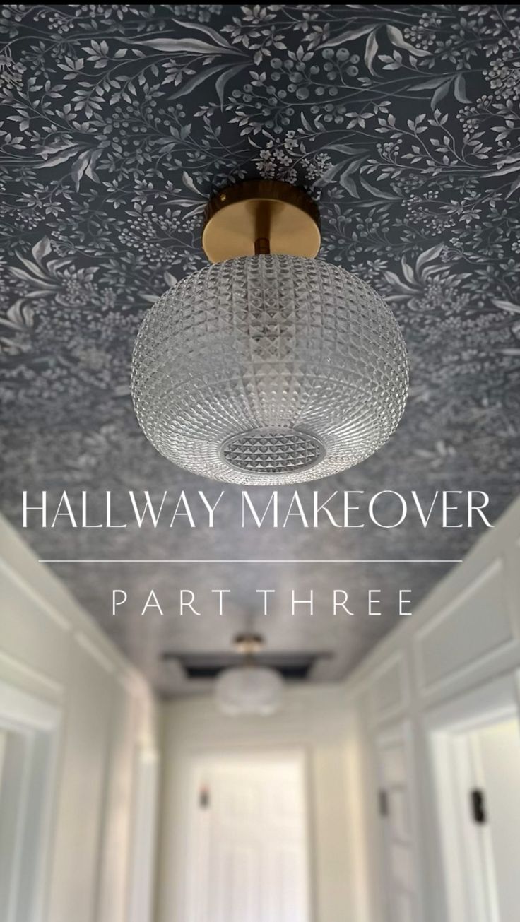 the hallway is decorated with floral wallpaper and a chandelier hanging from the ceiling