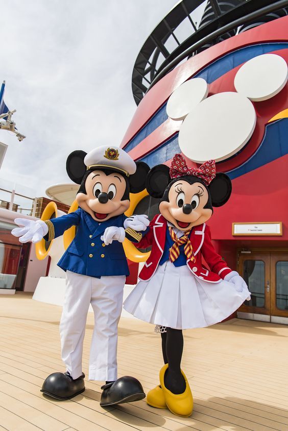 two mickey and minnie mouse characters standing in front of a disney cruise ship with their arms around each other