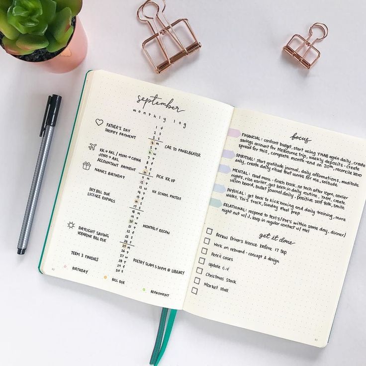 an open notebook sitting on top of a desk next to a pen and some office supplies