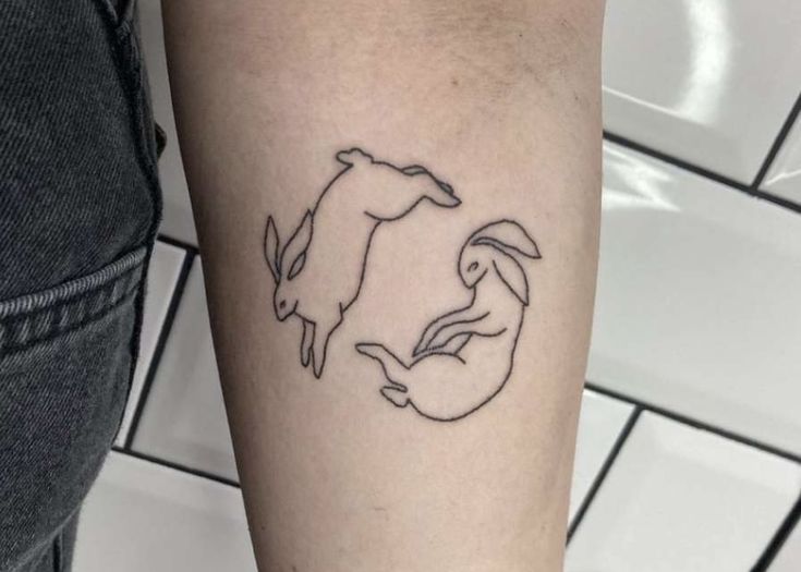 a tattoo on the arm of a person with a horse and rabbit in it's circle