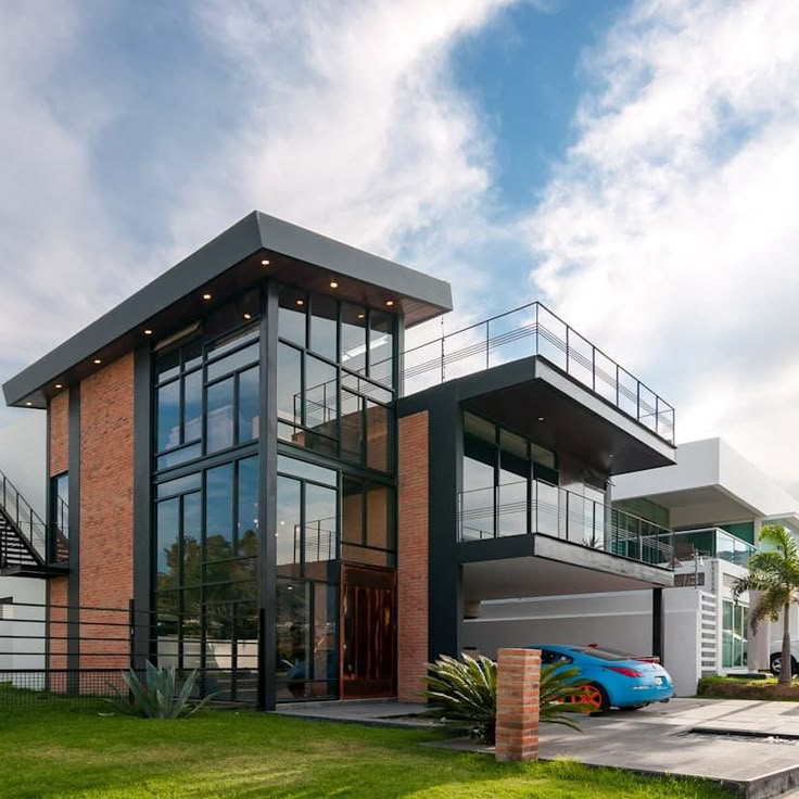 a modern house with a car parked in the driveway and stairs leading up to it