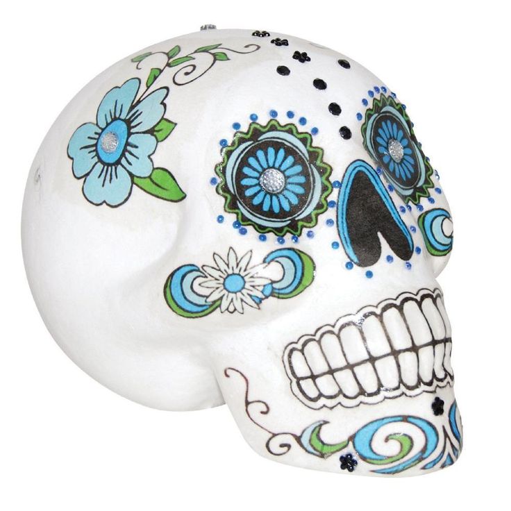 a white skull with blue and green flowers on it