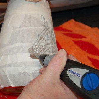 a person holding a piece of paper with a pen in their hand next to a roll of toilet paper