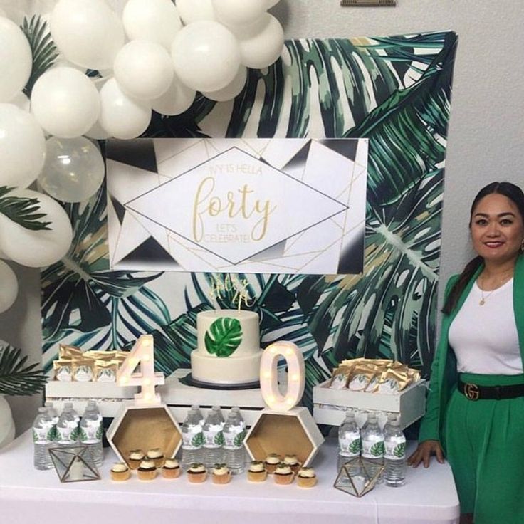 a woman standing in front of a table filled with desserts and balloons that say forty