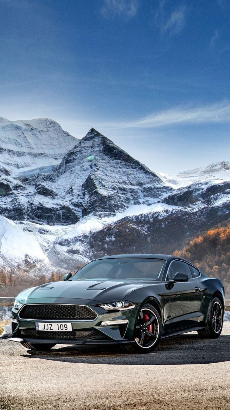 a car parked in front of a mountain with an apple logo on the back ground