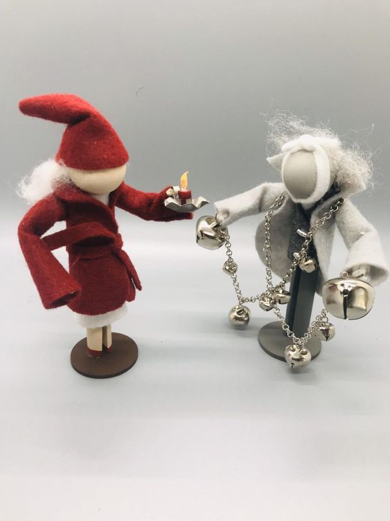 two small figurines one holding a lighter and the other wearing a santa hat