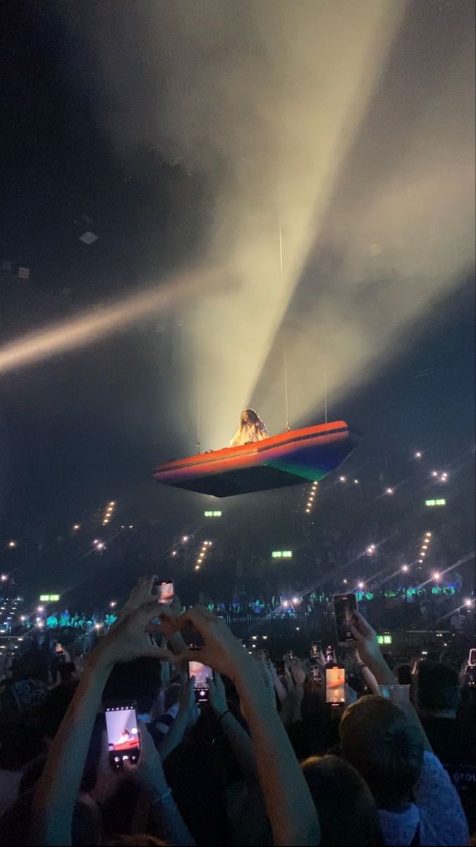 people are taking pictures with their cell phones at a concert in front of an audience