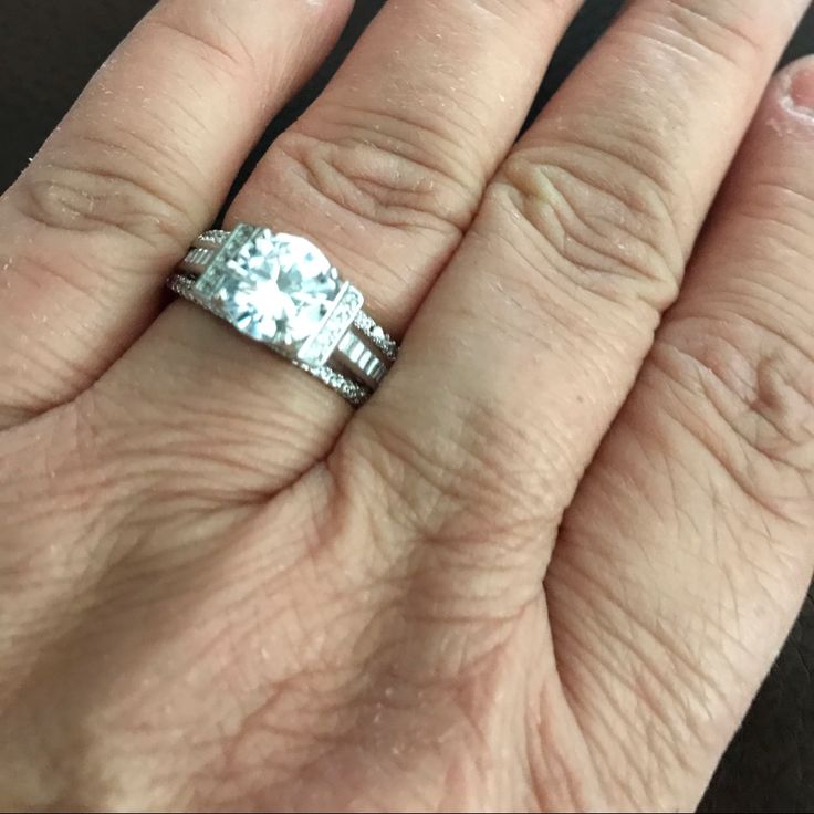 a woman's hand with a ring on it and an engagement band in the middle