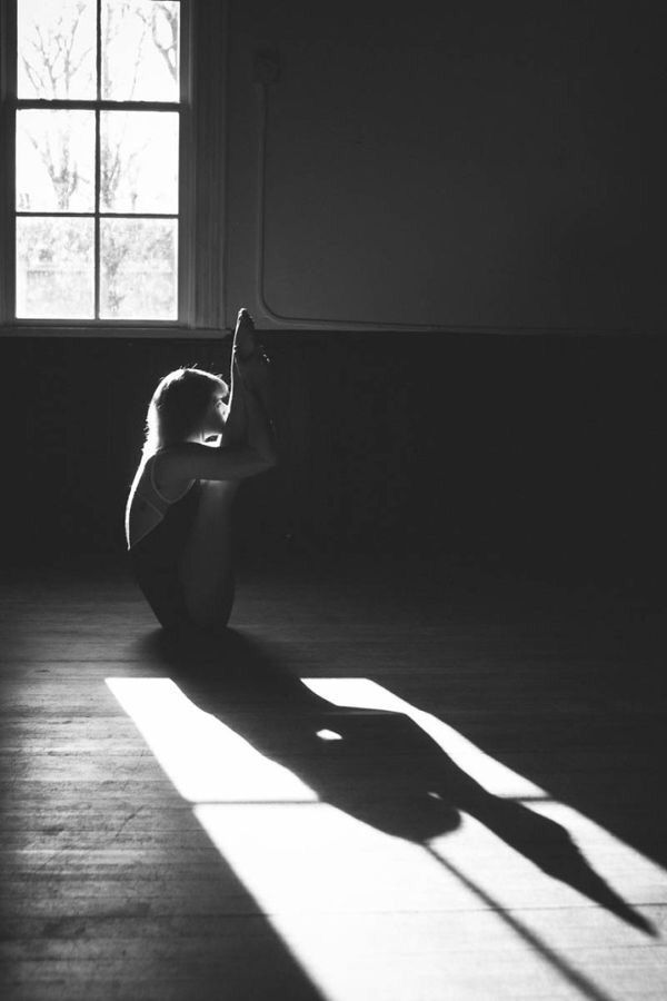 a woman sitting on the floor in front of a window