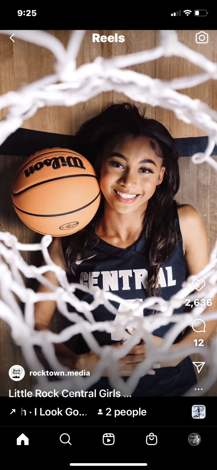 a woman holding a basketball in front of a net