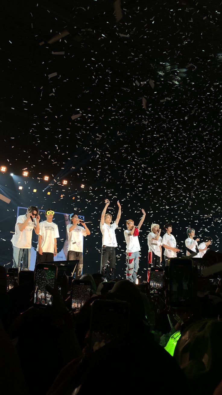 a group of people on stage with confetti falling in the air above them