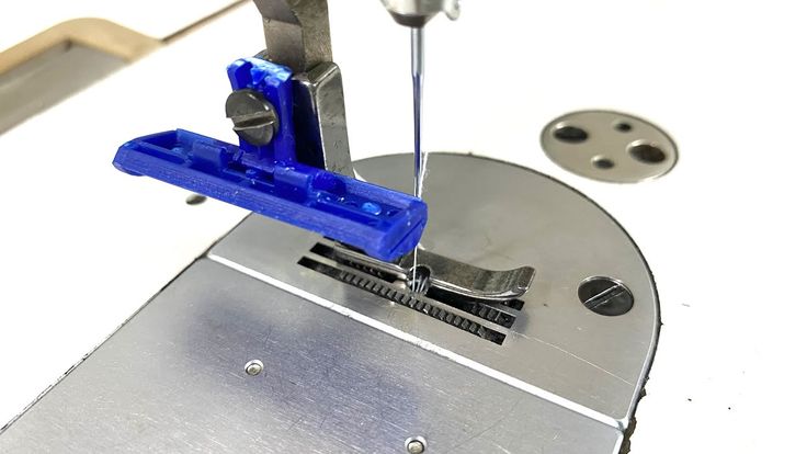 a machine that has some blue plastic on it's side and is cutting metal parts