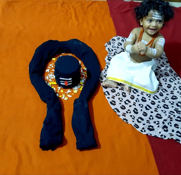 a doll sitting on top of an orange blanket