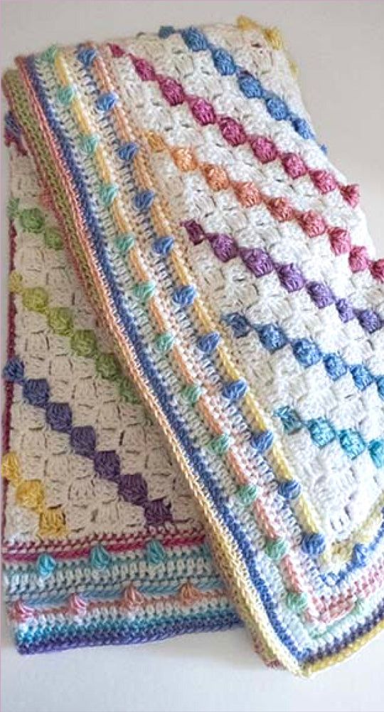 two crocheted blankets sitting next to each other