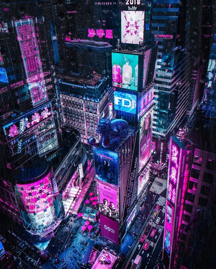 an aerial view of a city at night with neon lights and billboards on the buildings