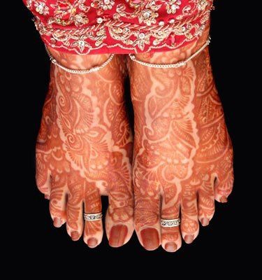 the legs and feet of a woman with henna tattoos