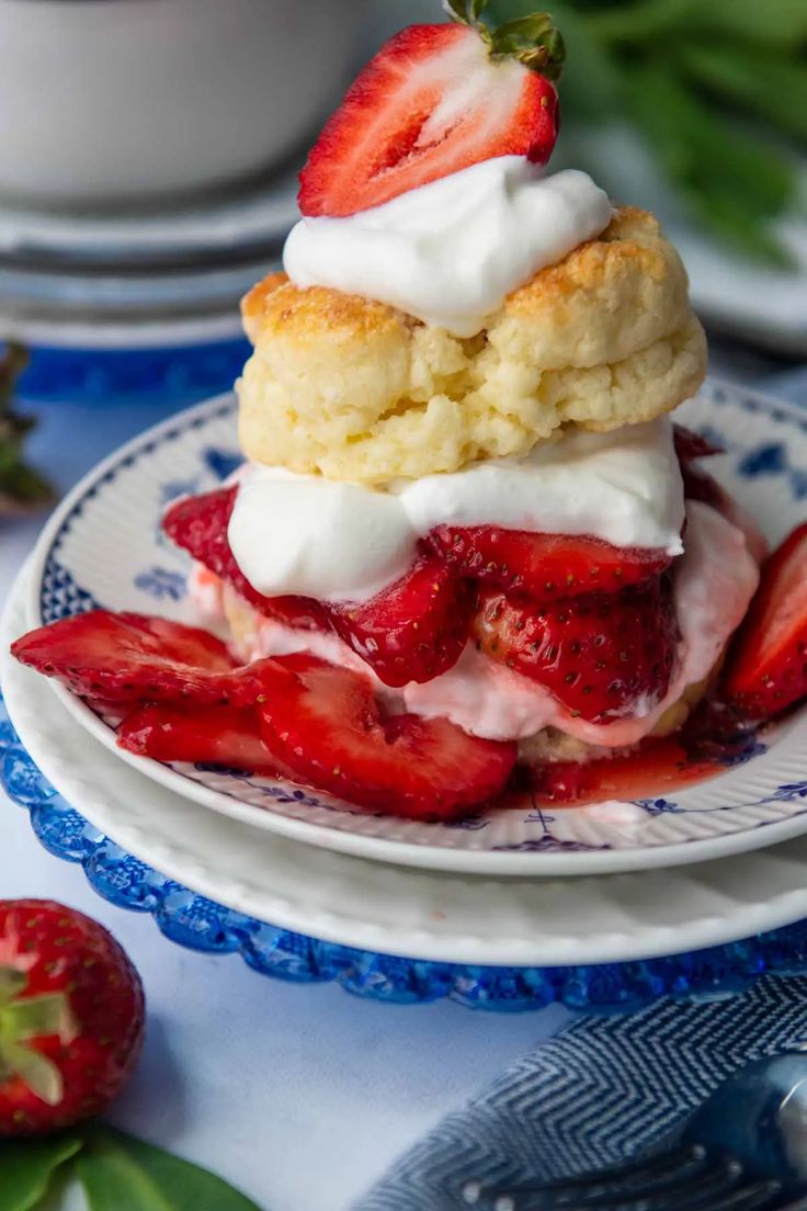 strawberry shortcakes with whipped cream and fresh strawberries on the side, ready to be eaten