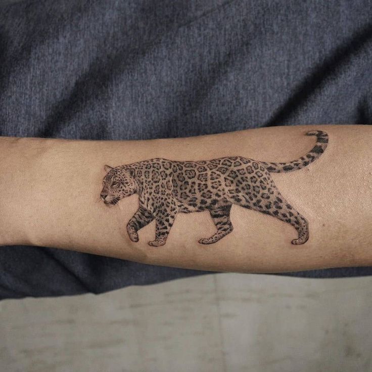 a man's arm with a tattoo of a leopard on it