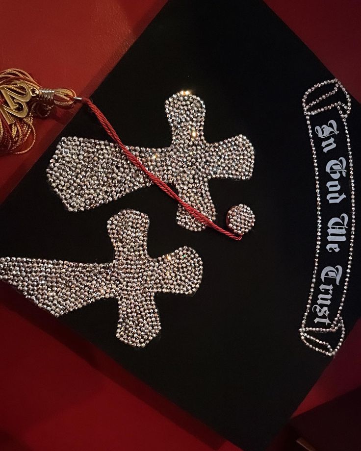 a graduation cap decorated with swaroons and ribbons on a red tablecloth that says st john's college