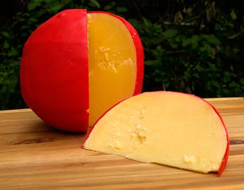 an apple and cheese cut in half sitting on a cutting board next to each other