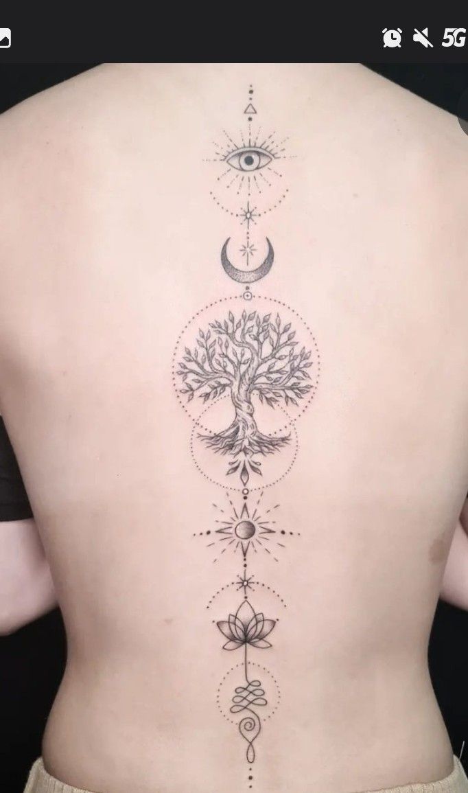 the back of a woman's body with an intricate tree and moon tattoo on it