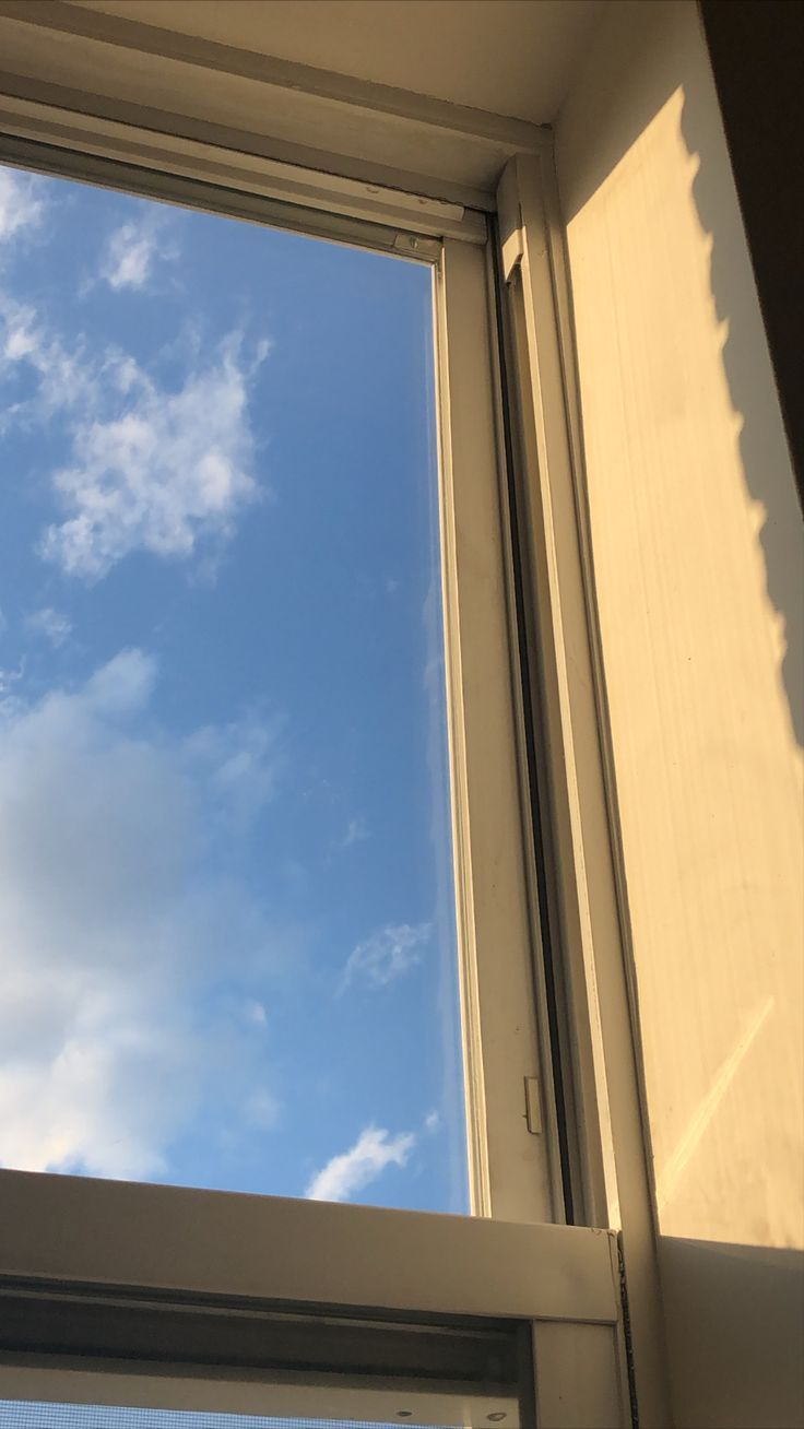 an open window with the sky in the background