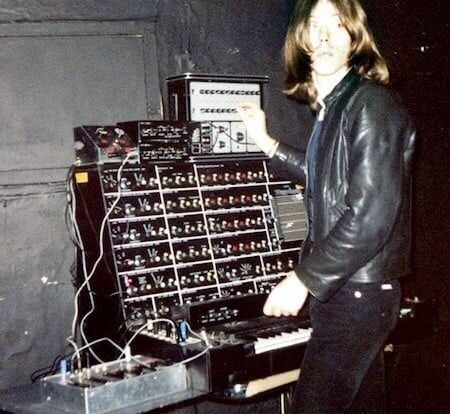 a man standing in front of an array of electronic equipment