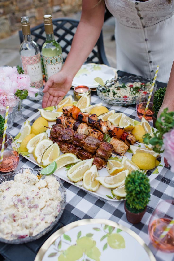 a table topped with lots of food next to wine glasses and plates filled with food