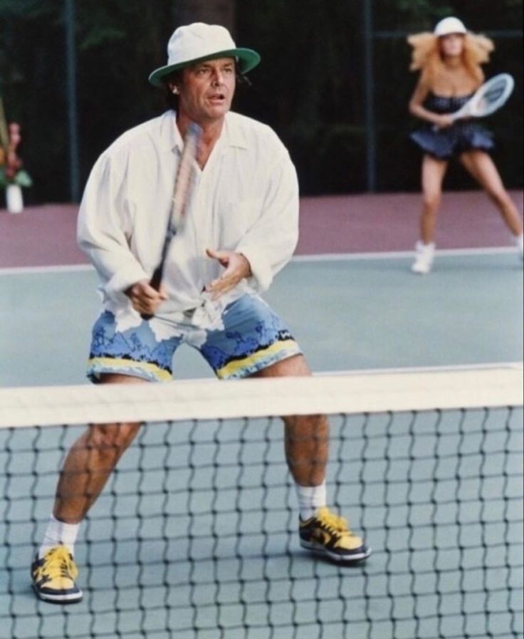 a man standing on top of a tennis court holding a racquet